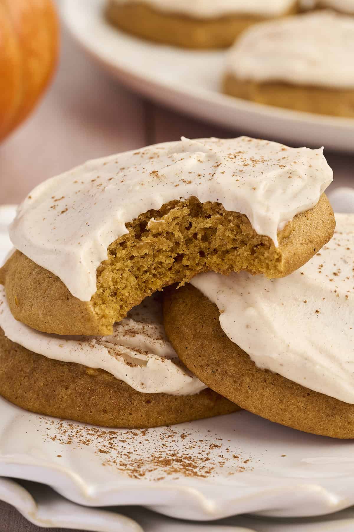 A soft pumpkin cookie with a bite taken out.