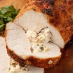 Sliced stuffed pork loin served for dinner with cheesy filling visible in each piece.