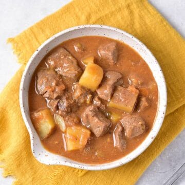 A bowl of rich venison stew with potatoes.