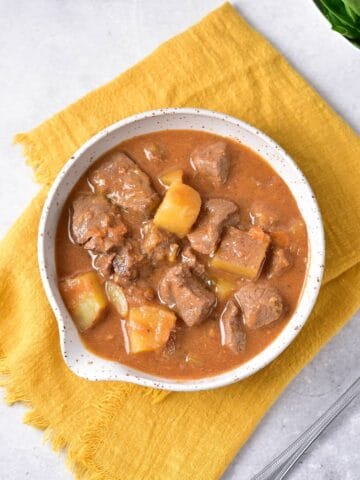 A bowl of rich venison stew with potatoes.