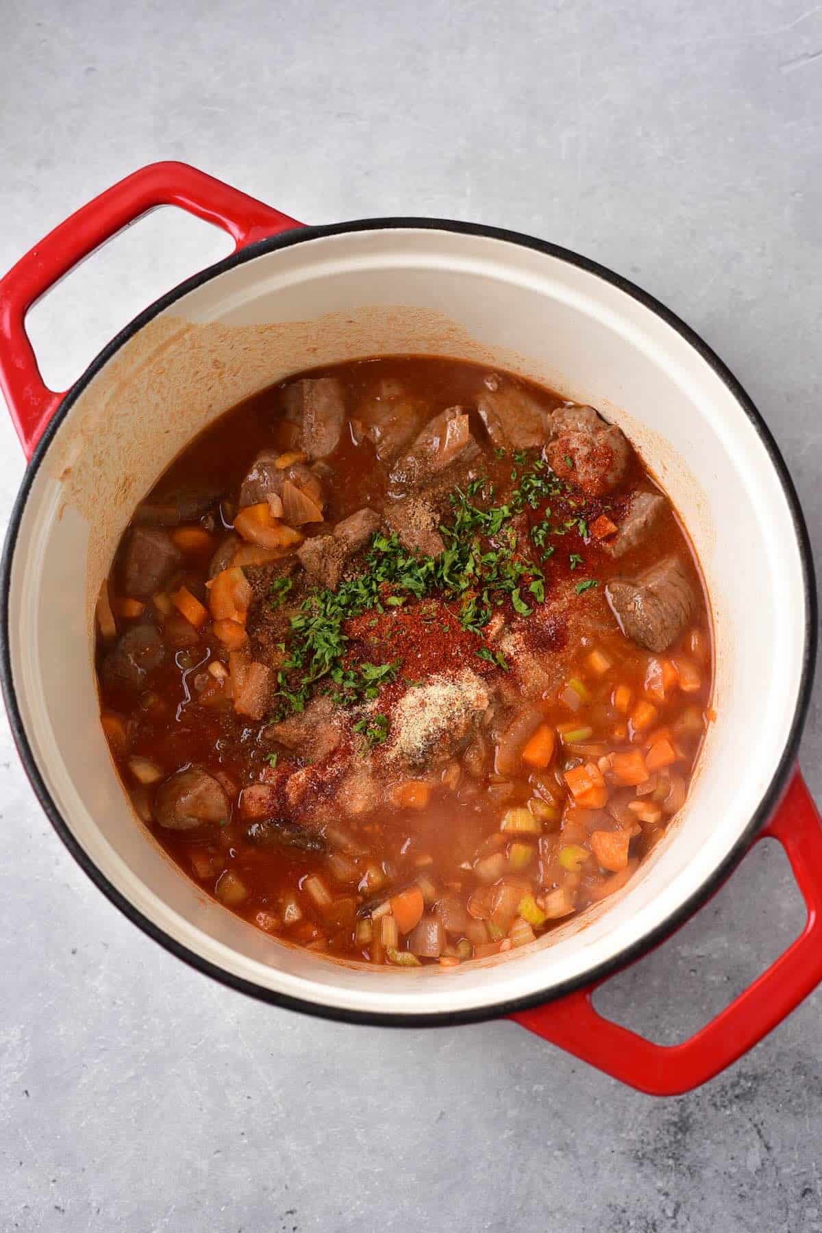 Venison stew simmering in a Dutch oven with spices.
