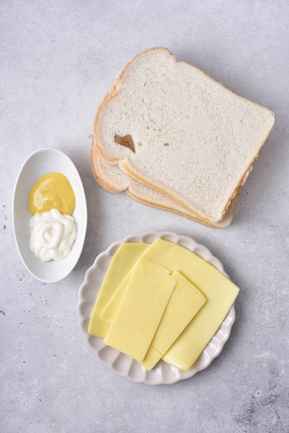 Ingredients to make grilled cheese in the air fryer with bread, cheese, mayo and Dijon mustard.
