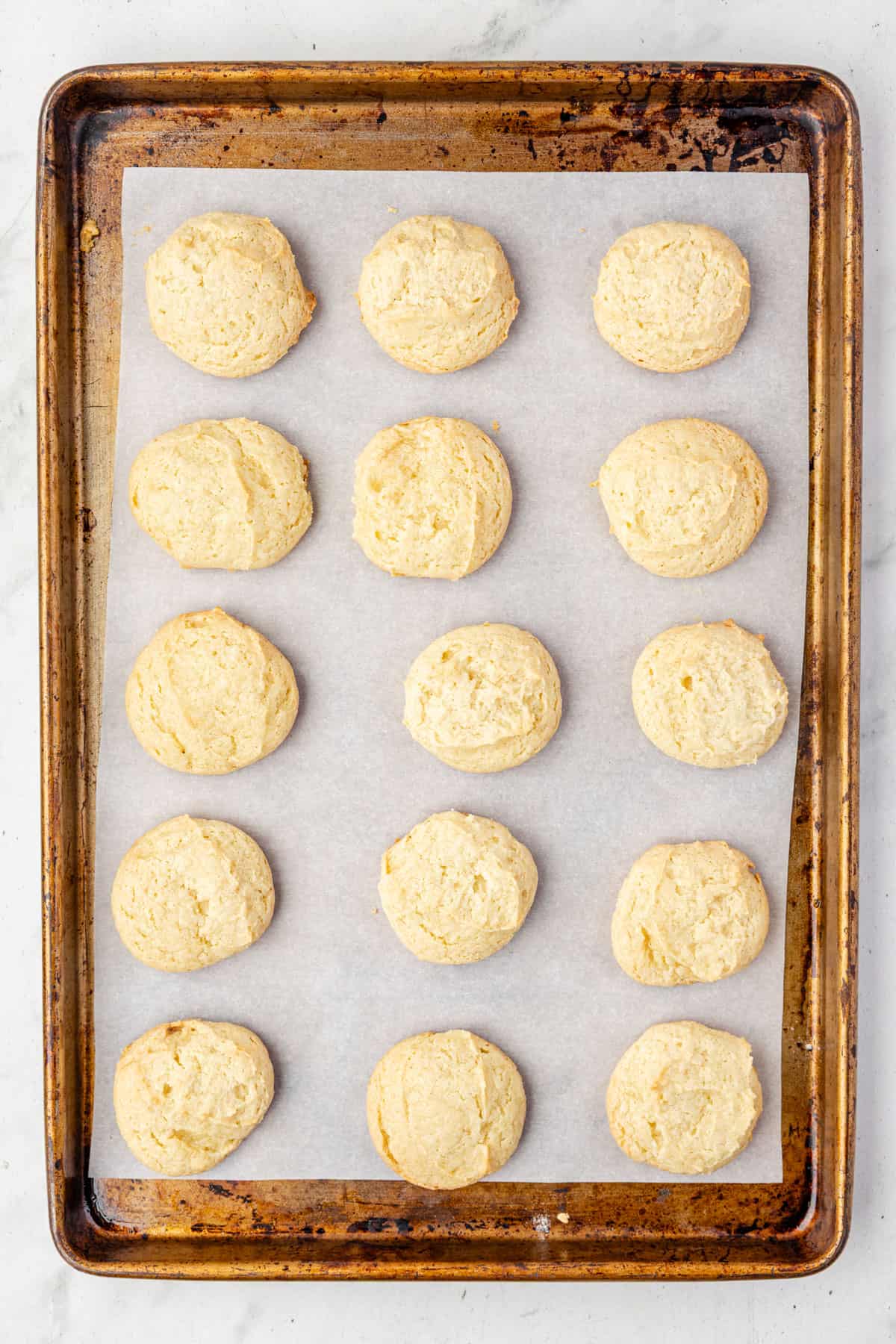 Freshly baked cookies cooling on a baking sheet.