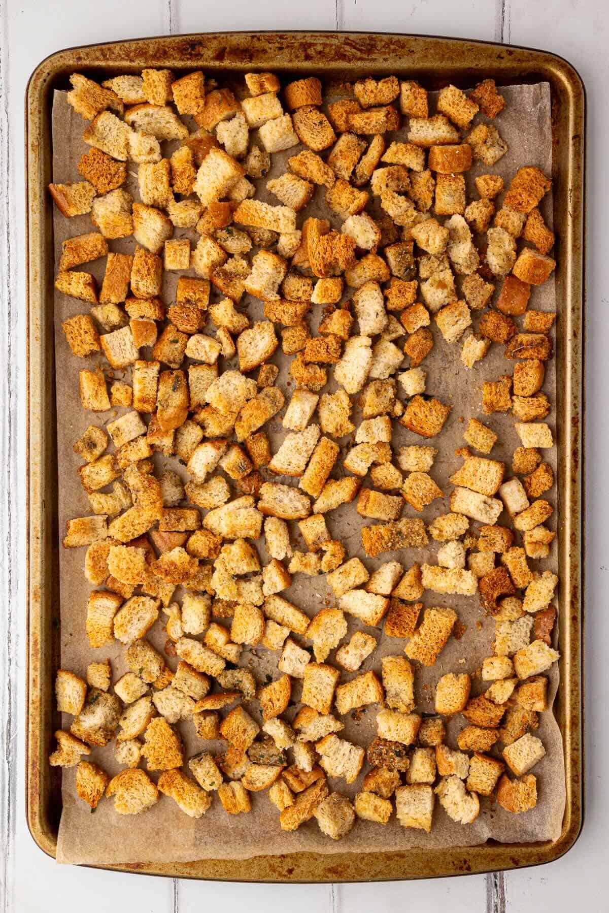 Bread cubes spread in a single layer on a baking sheet, baked to golden perfection.