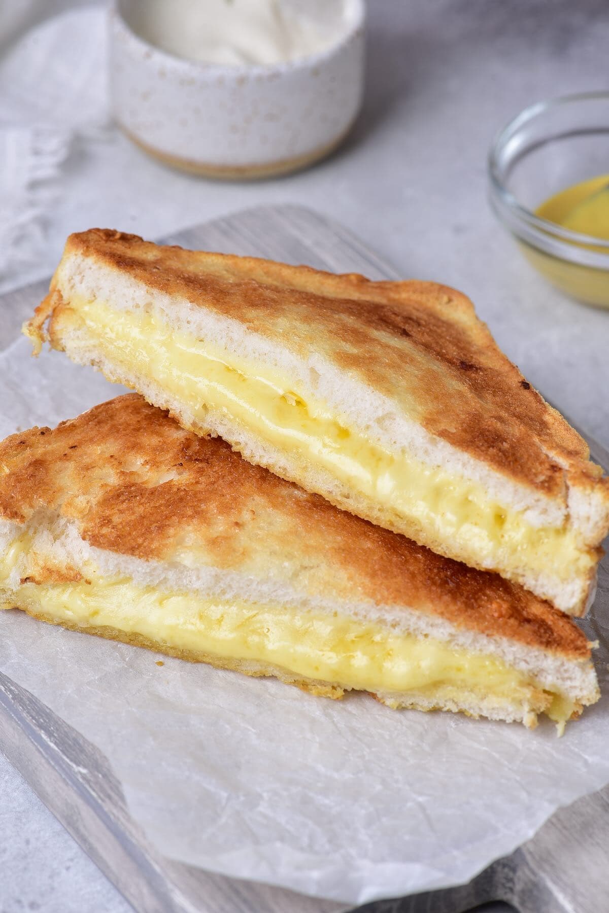 Golden brown air fryer grilled cheese sandwich cut in half with gooey melted cheddar inside.