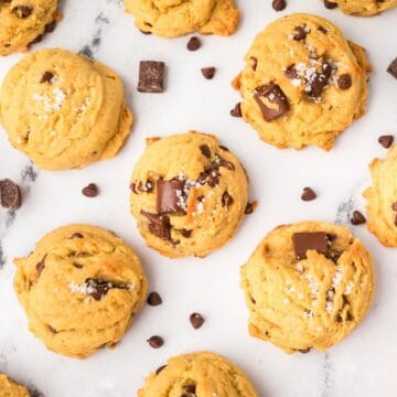 Chewy brown butter sourdough chocolate chip cookies on a cooling rack with melty chocolate chips.
