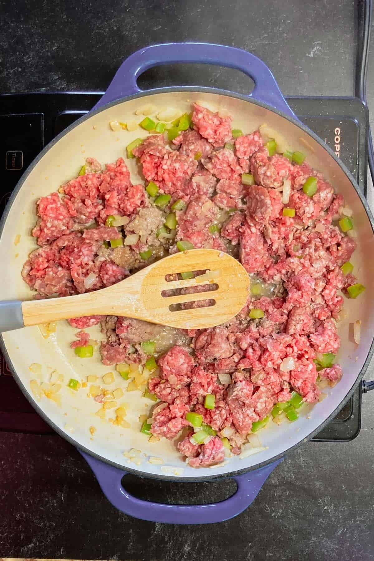 Pound of ground beef browning in a skillet over medium low heat.