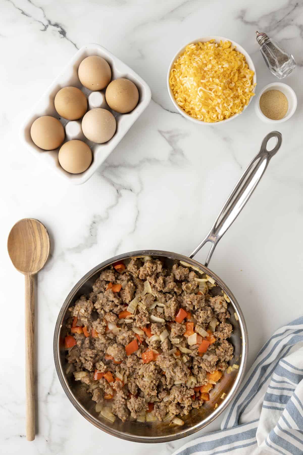 Cooking sausage in skillet until browned and crumbly for egg casserole.