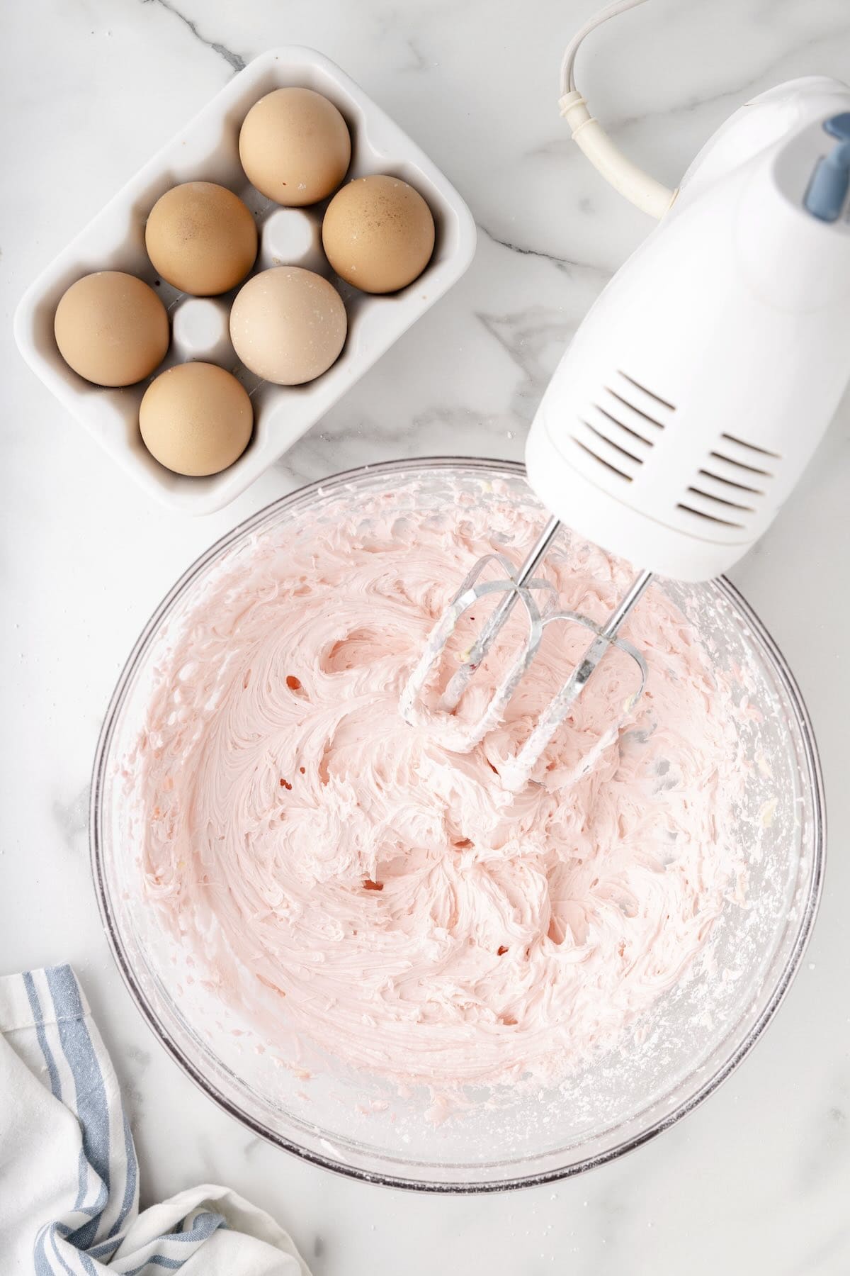 Using a hand mixer to make buttercream frosting.