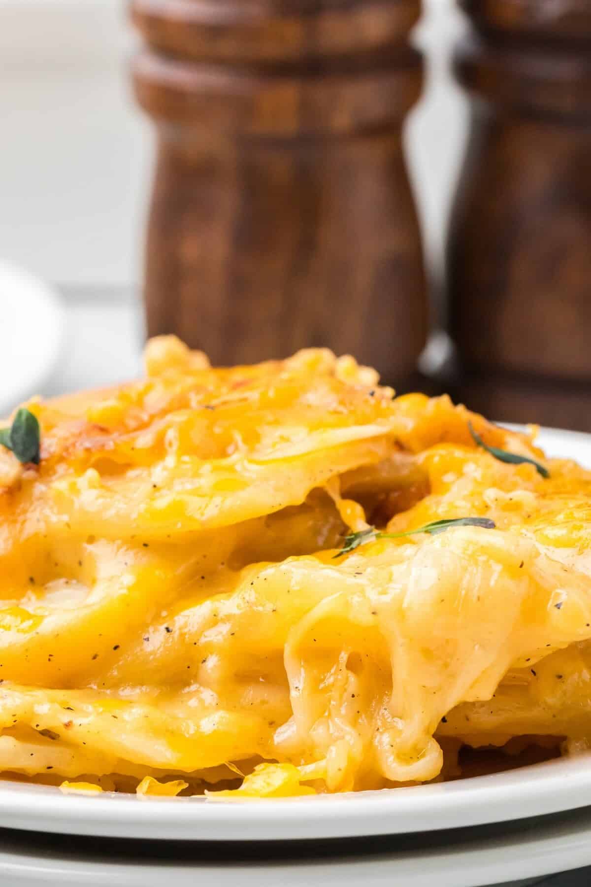 Close-up of creamy, cheesy layers of scalloped potatoes showing melted cheddar.