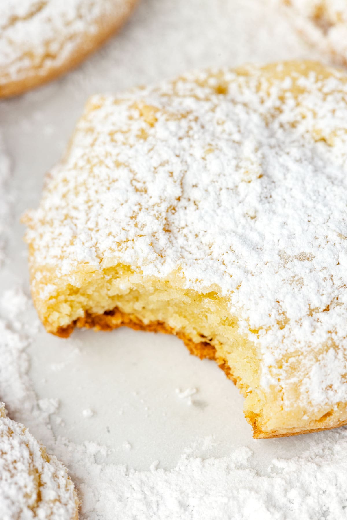 A bite taken out of a cream cheese cookie to show the light and fluffy texture.