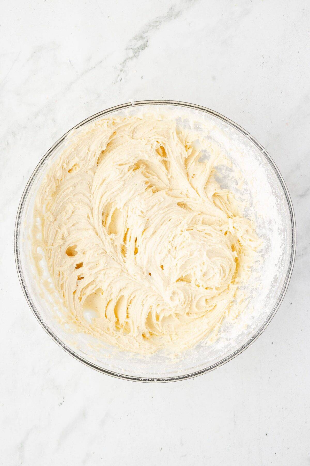 Cream cheese cookie dough batter in a glass bowl.