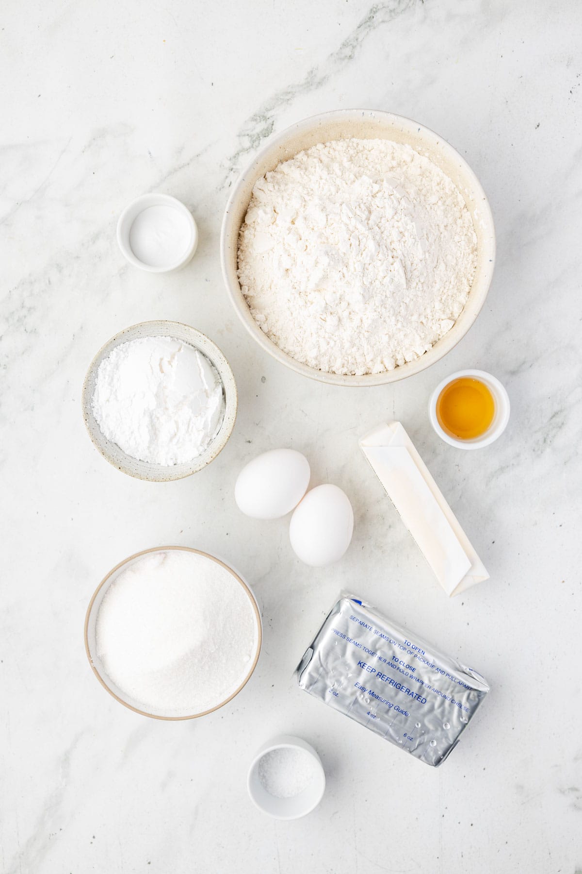 Ingredients to make cream cheese cookies including cream cheese, flour, vanilla and flour.