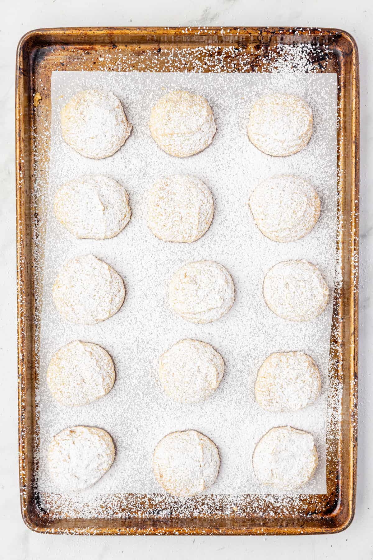 Powdered sugar sprinkled over soft cream cheese cookies after baking.