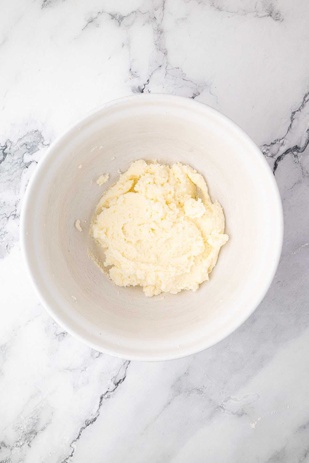 Mixing butter and sugar together in a bowl until light and fluffy for banana bread batter.