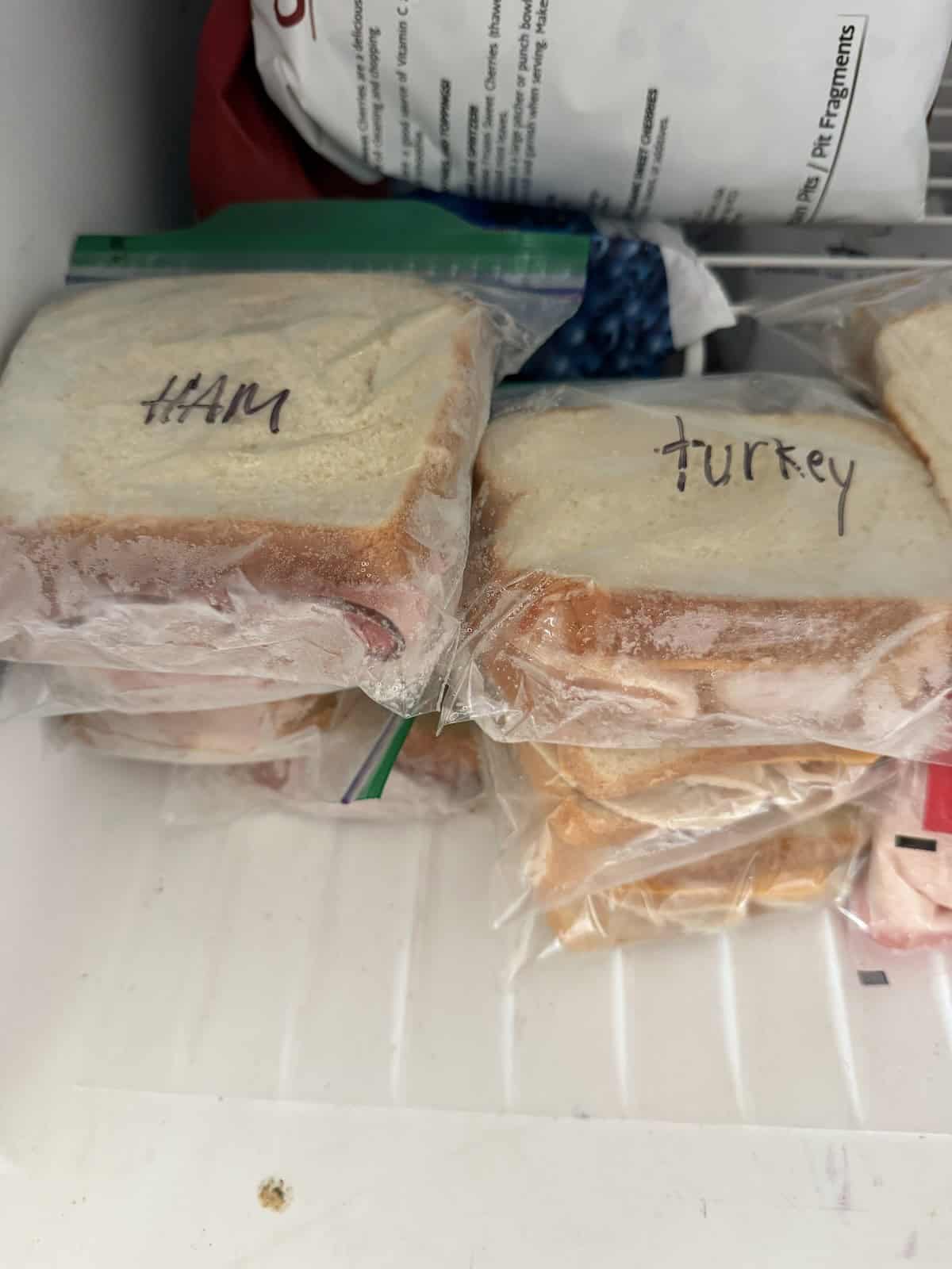 Stacks of ham and turkey sandwiches frozen in the freezer, ready to grab and go.