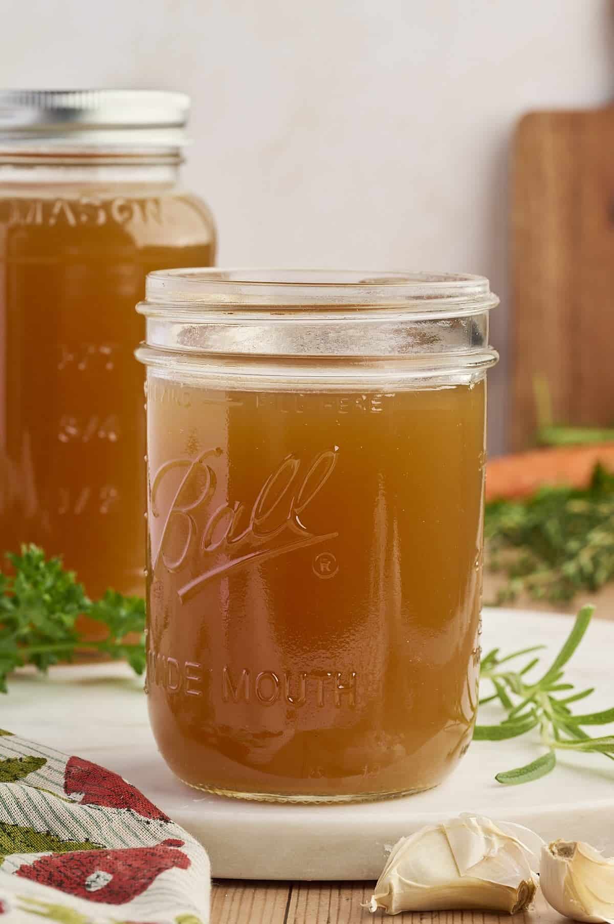 Mason jars filled with hearty homemade chicken broth.