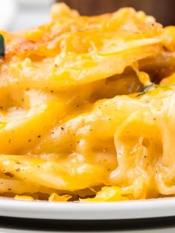 Close-up of creamy, cheesy layers of scalloped potatoes showing melted cheddar.