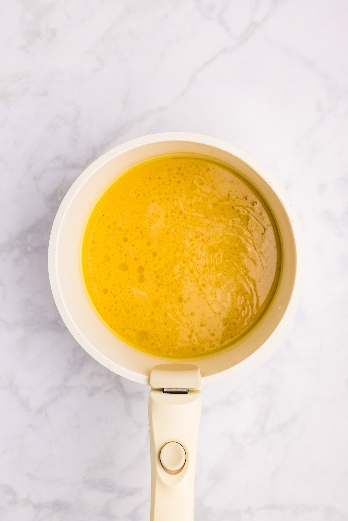 Pan drippings with broth and cornstarch in a saucepan to make smooth, golden homemade turkey gravy.