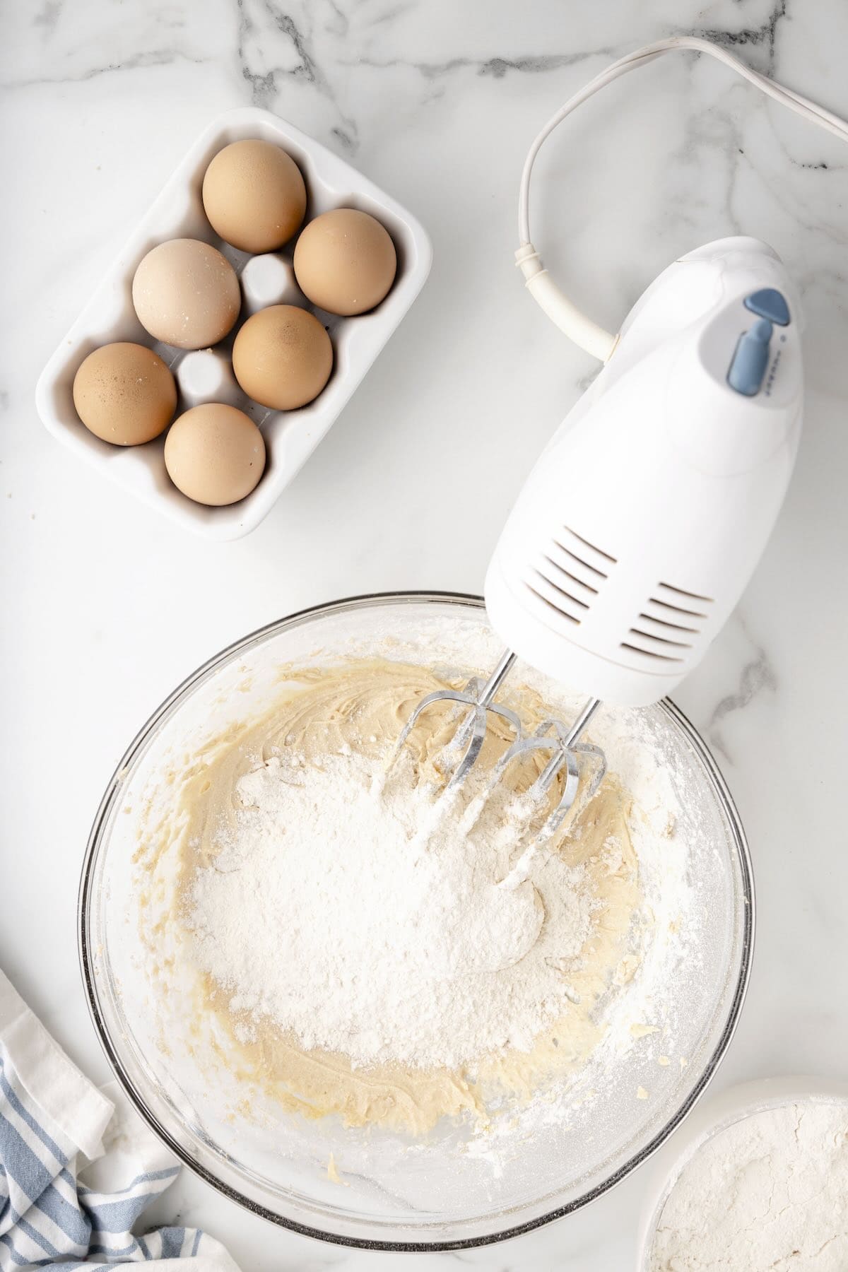 Mixing flour, baking powder, and baking soda into the sugar cookie bar dough.