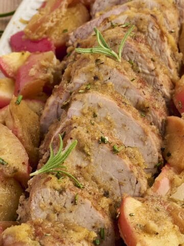 Slices of honey-glazed pork tenderloin served with roasted apples and pan sauce.