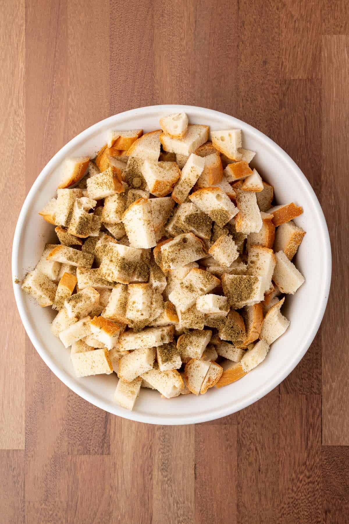 Seasoned bread cubes in a large bowl.