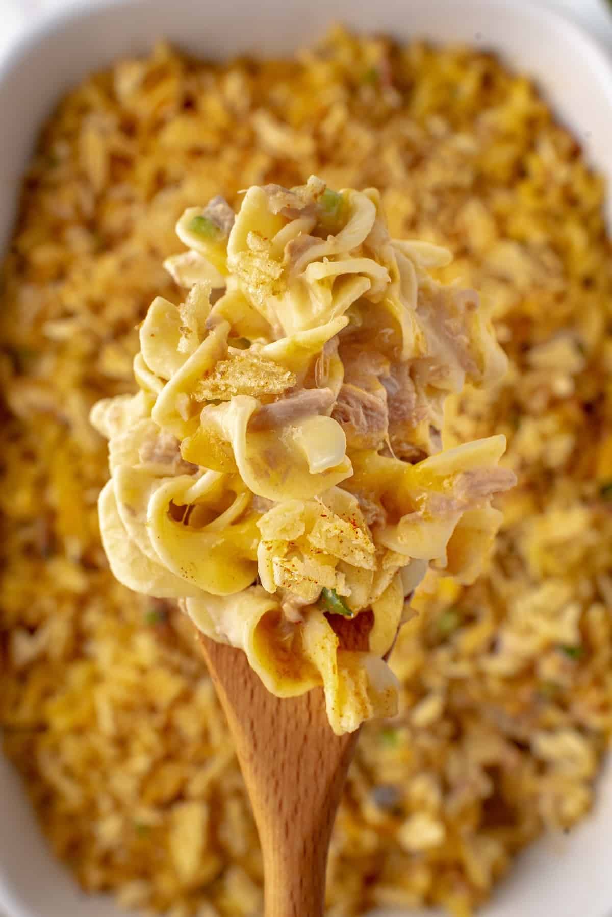 Serving tuna casserole on a wooden spoon.