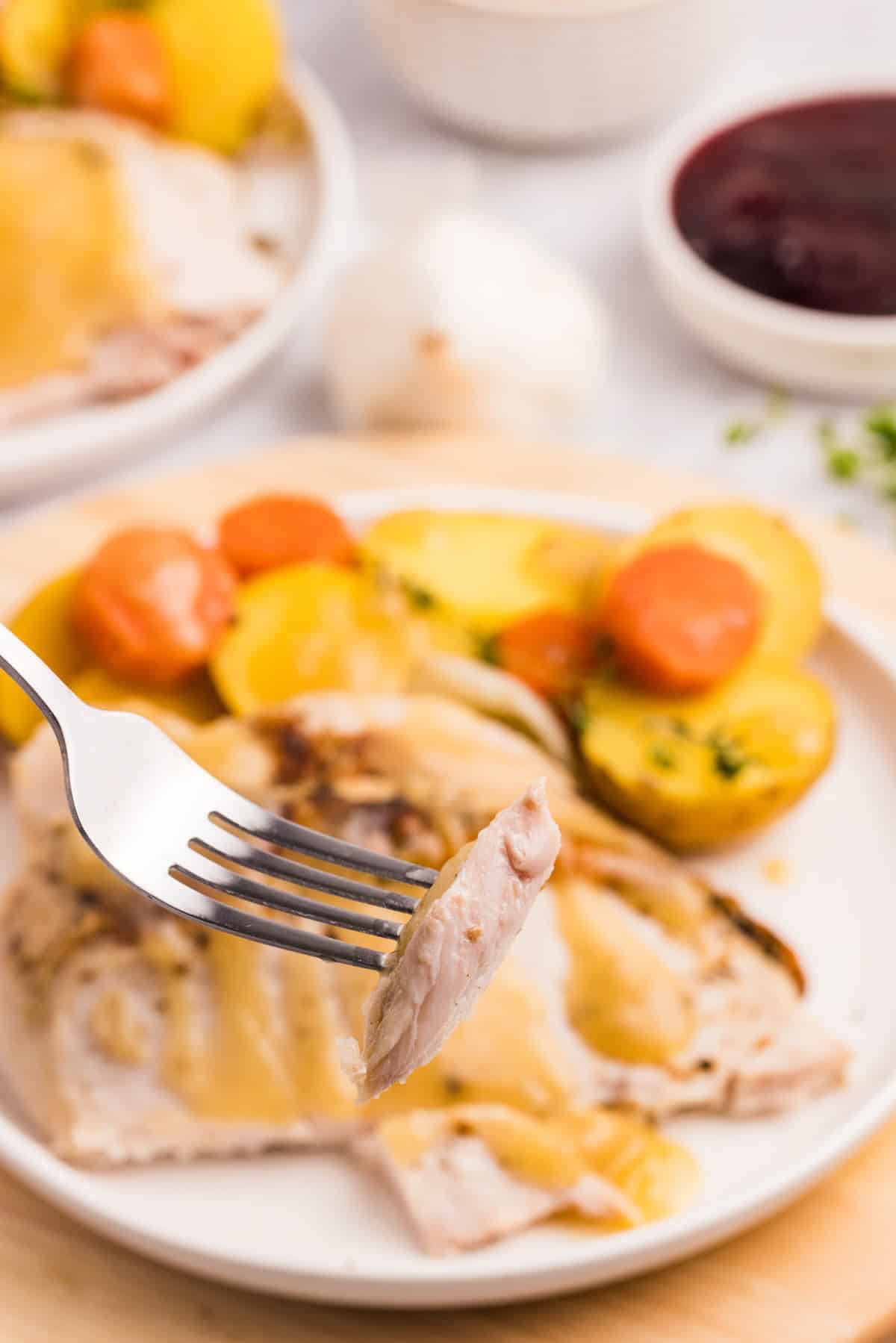 A juicy bite of turkey on a fork.