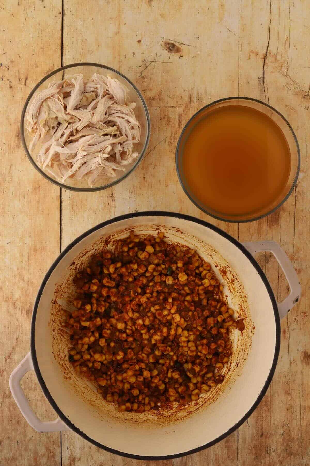 Fire-roasted corn, diced green chiles, and taco seasoning added to the pot and stirred together.