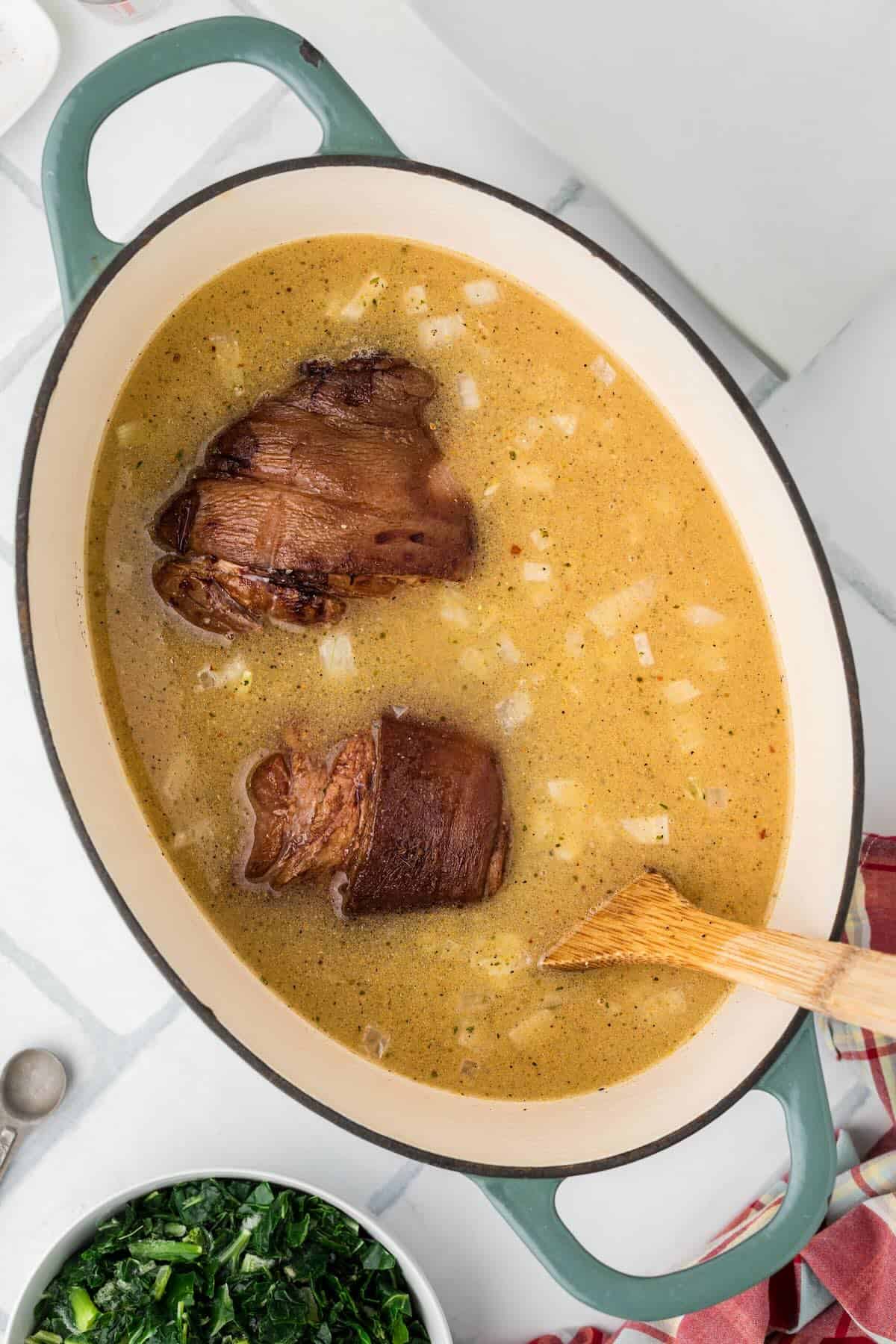 Ham hocks placed into the seasoned broth.