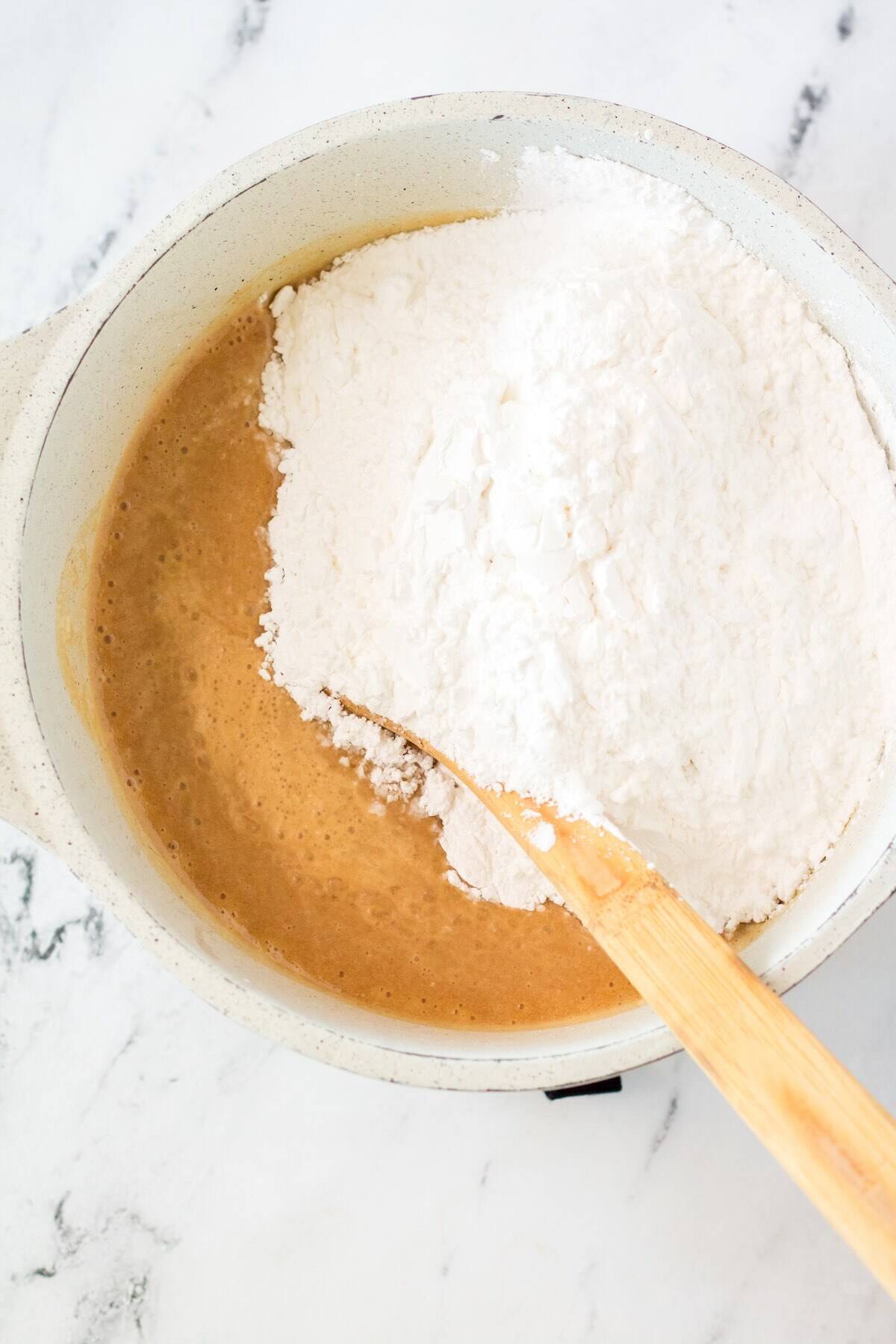 Powdered sugar being added to warm peanut butter mixture.