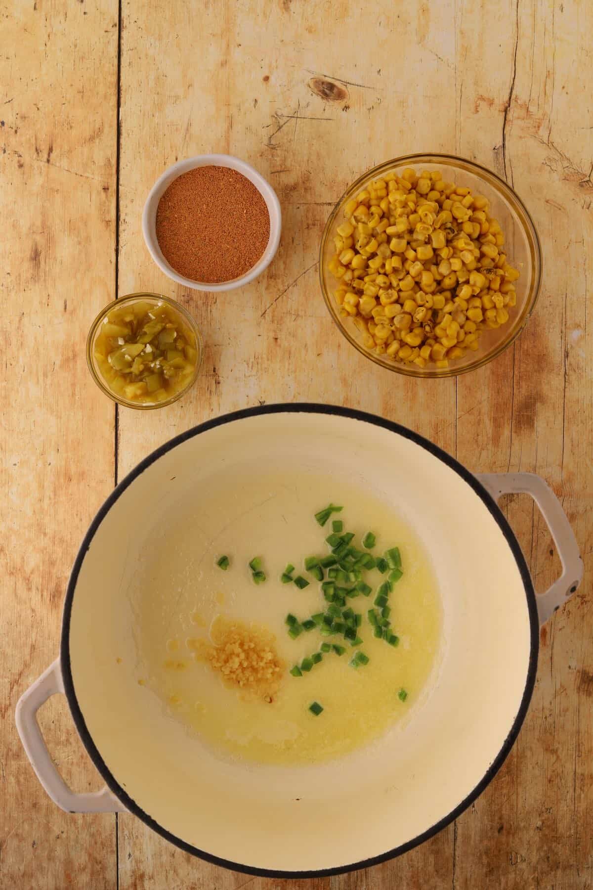 Melted butter, minced garlic and jalapanos softening in a Dutch oven.