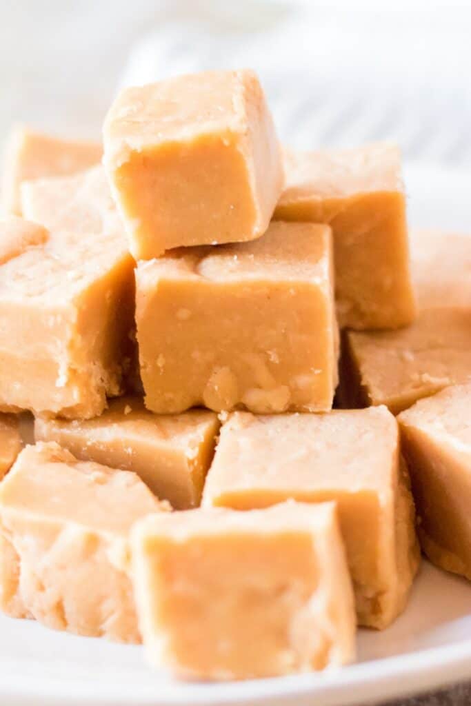 Small squares of easy microwave peanut butter fudge arranged on a plate, ready to serve.