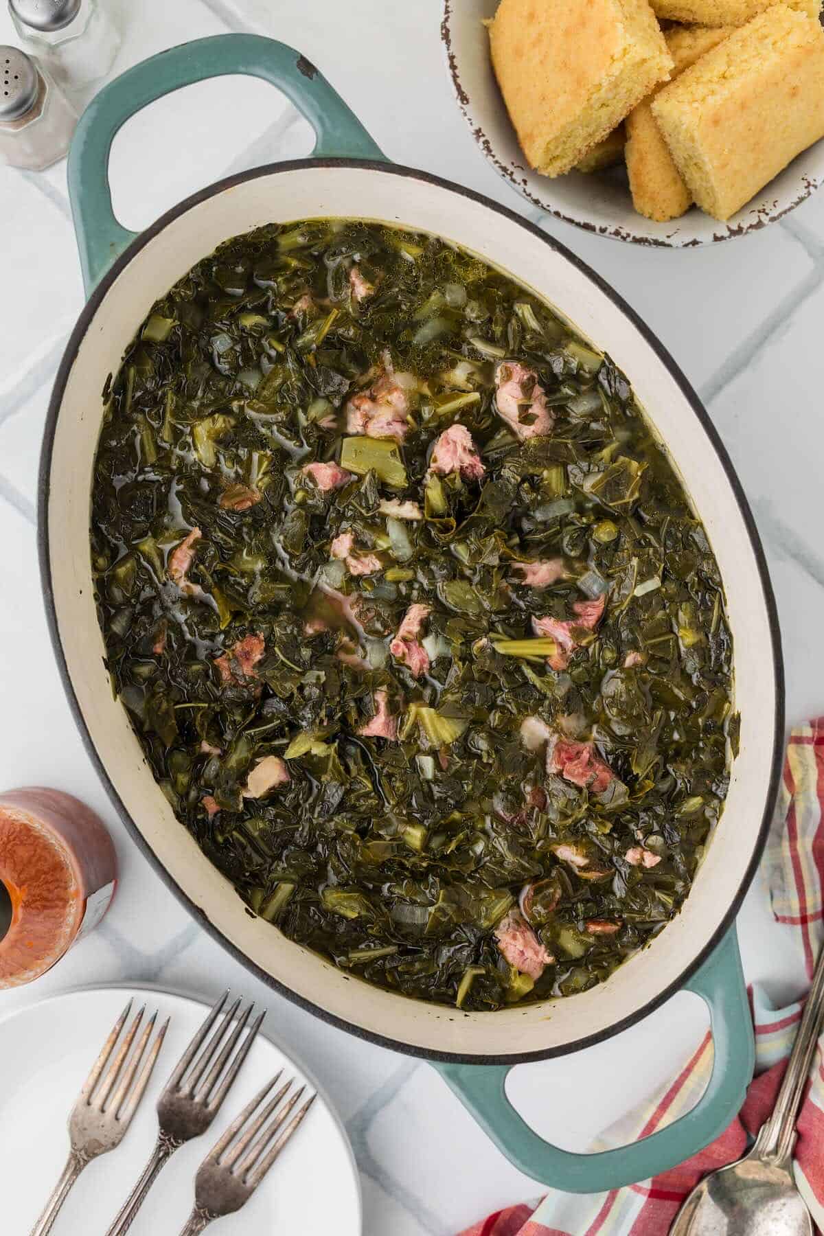 Fully cooked southern-style collard greens with ham hock pieces and a rich broth.