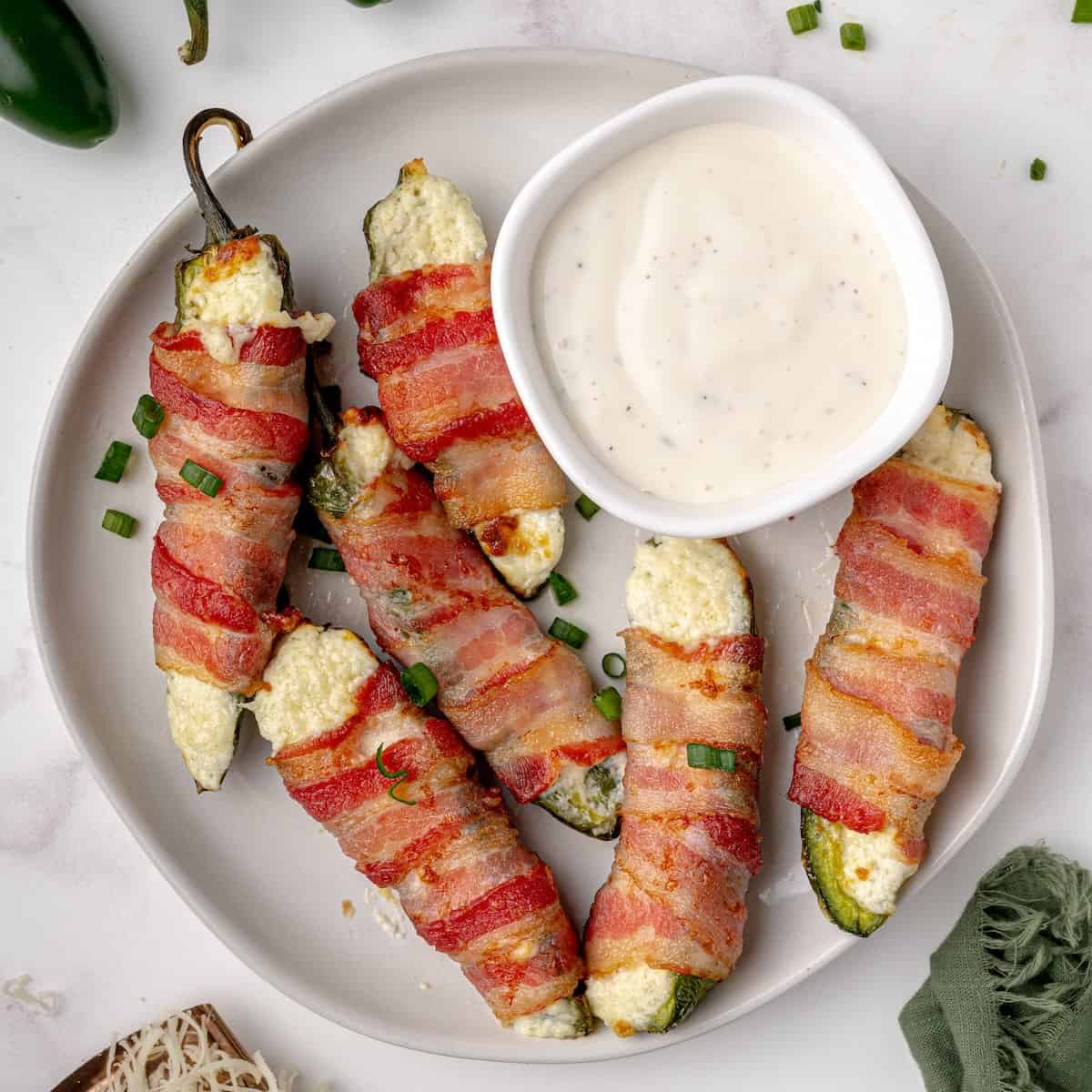 Homemade jalapeño poppers served on a platter with ranch for dipping.