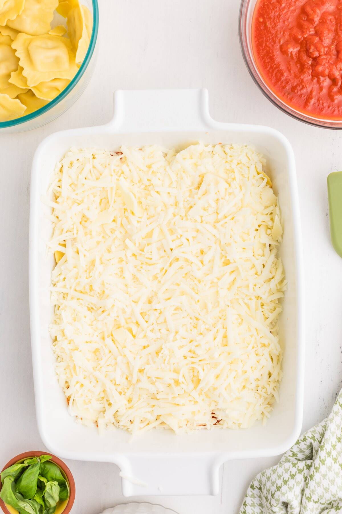 Shredded mozzarella sprinkled over cottage cheese and ravioli for the lasagna layers.