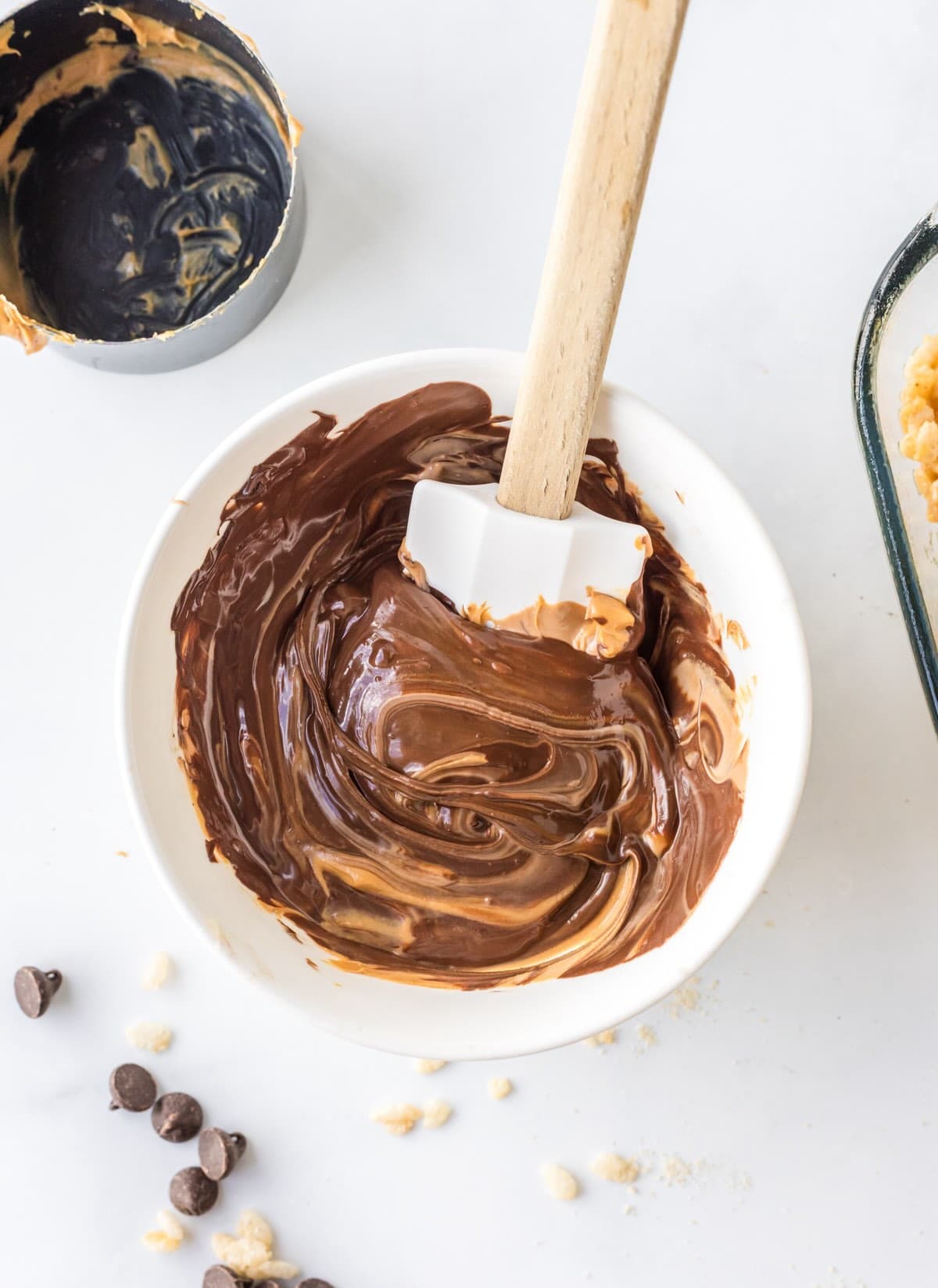 Chocolate and butterscotch chips melting together in microwave-safe bowl for scotcharoo topping.
