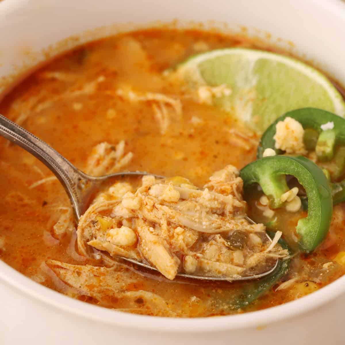 Spoonful of Mexican street corn soup showing tender chicken, fire-roasted corn, and rich broth.