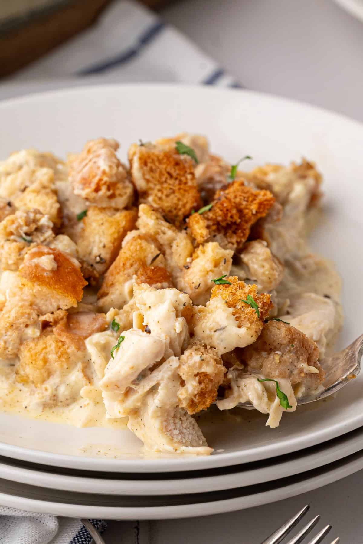 A serving of chicken and stuffing bake on a plate showing the creamy filling and crispy topping.
