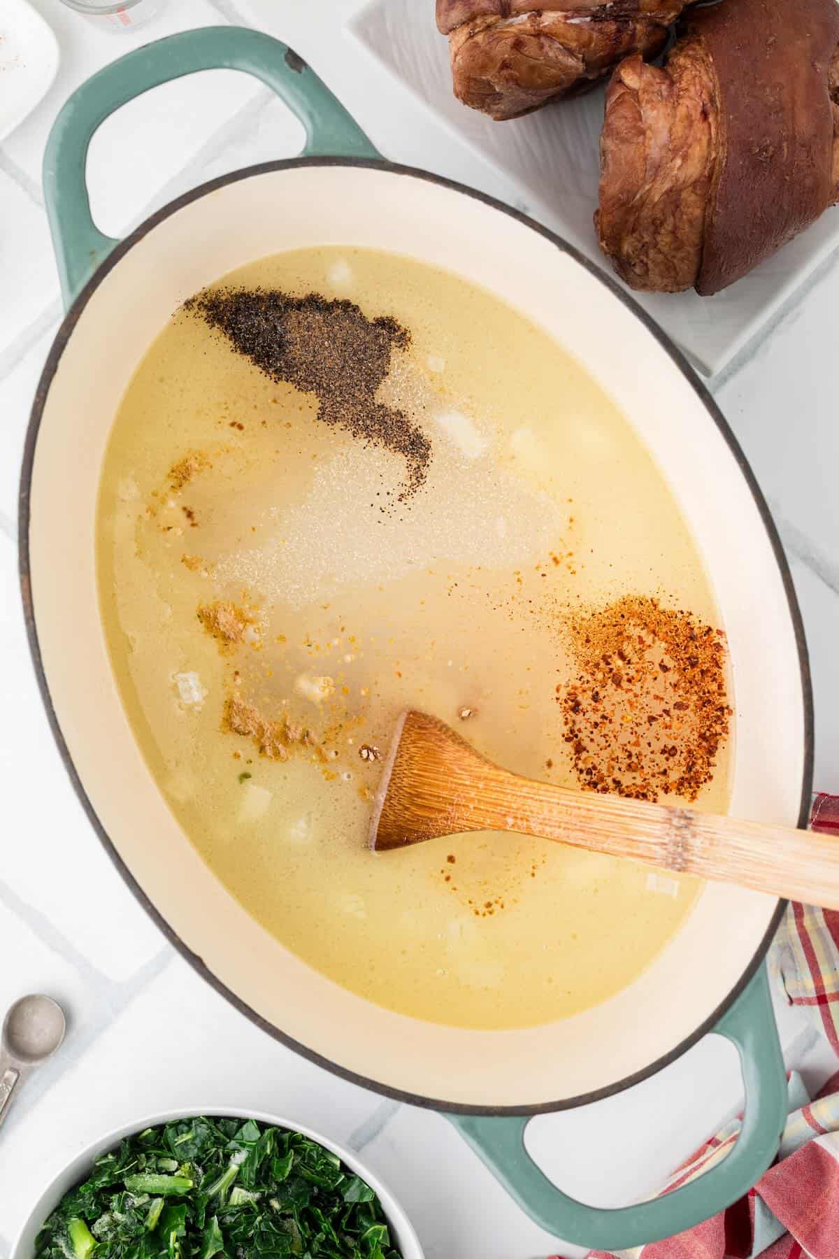 Chicken bouillon, spices, and water stirred together in a large pot to build a flavorful broth.