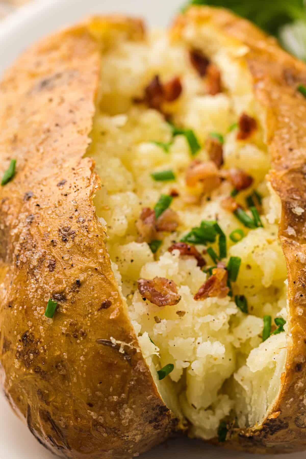 A baked potato topped with bacon and chives from a potato party.