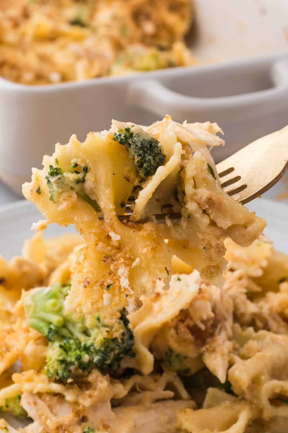 A forkful of farfalle pasta, tender broccoli and chicken topped lightly with toasted breadcrumbs.