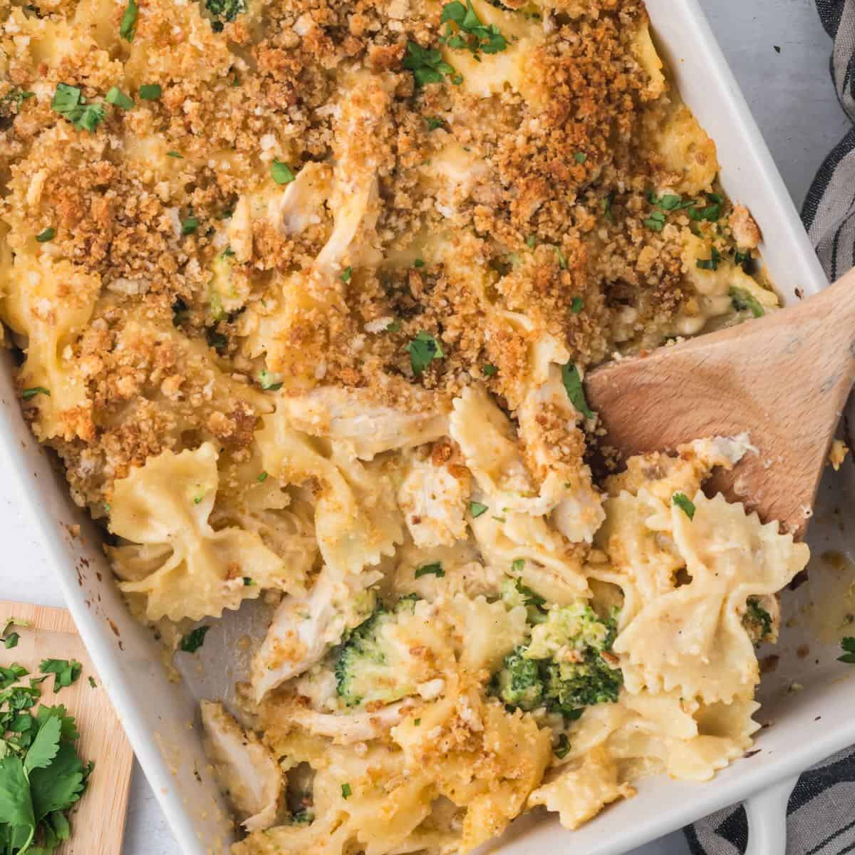 A spoonful of a cheesy casserole with chicken and broccoli.