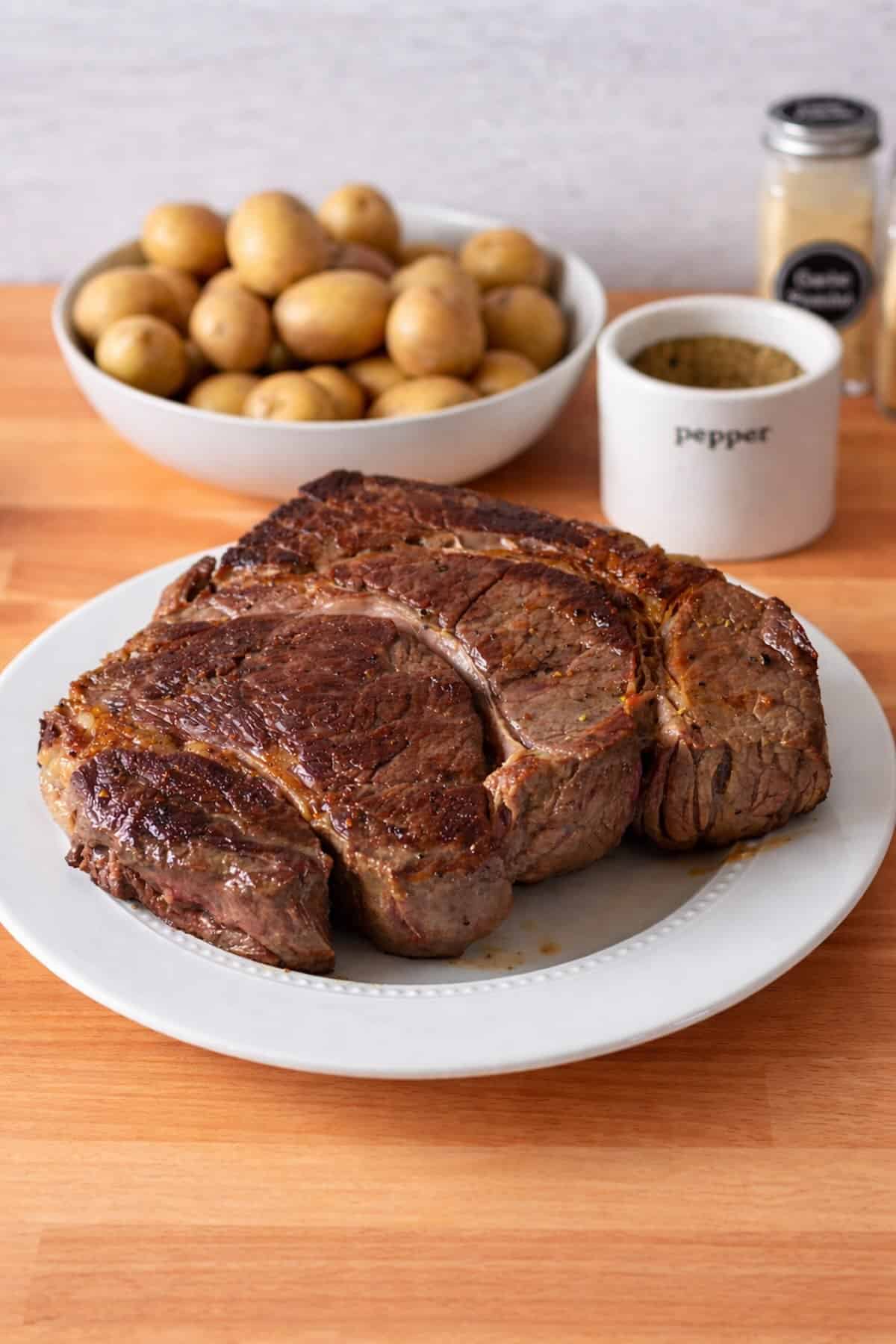 A chuck roast that has been seared on both side, waiting to go in the Dutch oven.