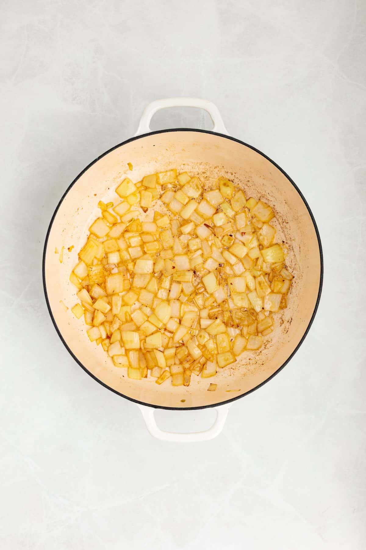 Onions sautéing in skillet before adding sausage.