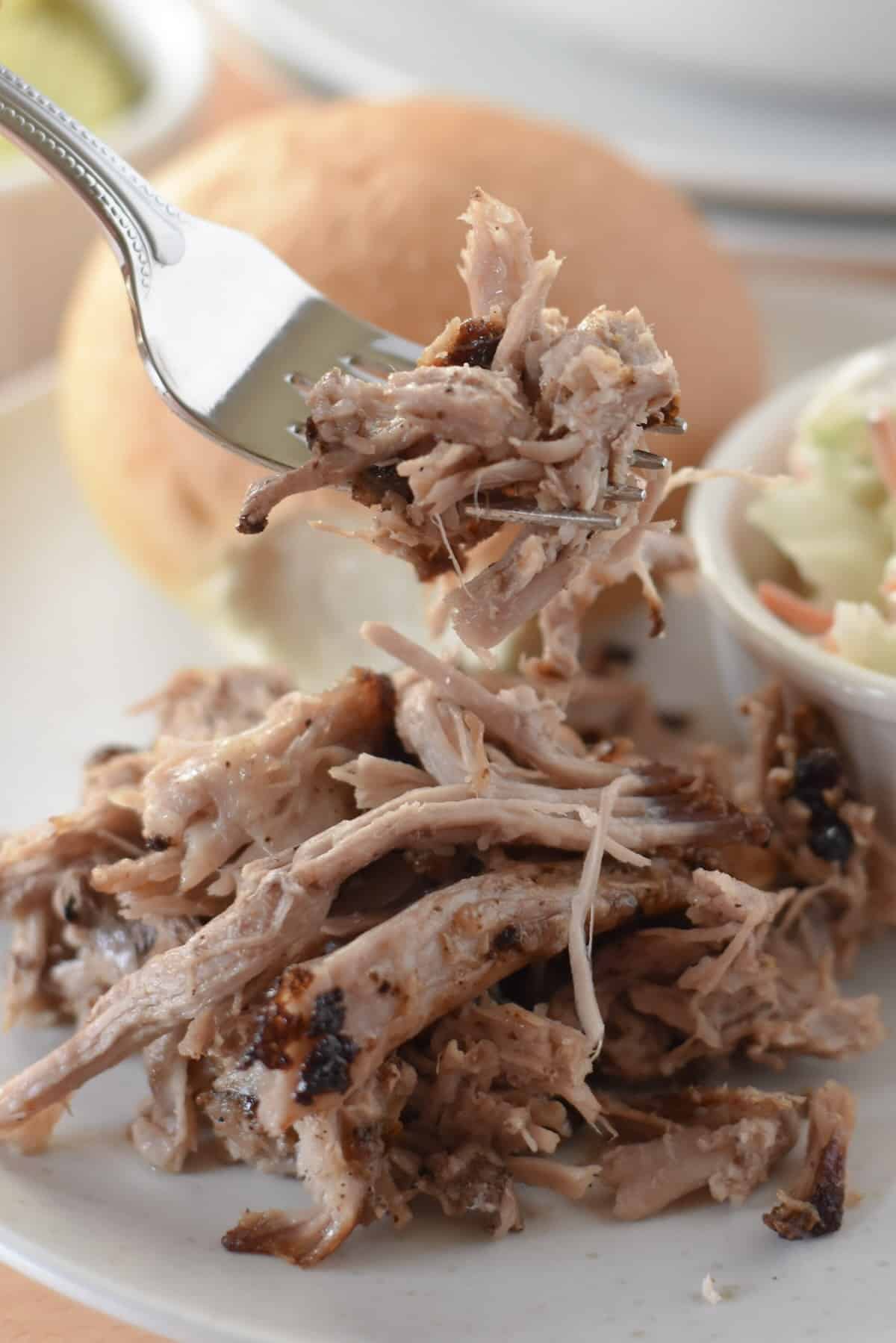 Close-up bite of air fryer pulled pork showing tender shredded pork.