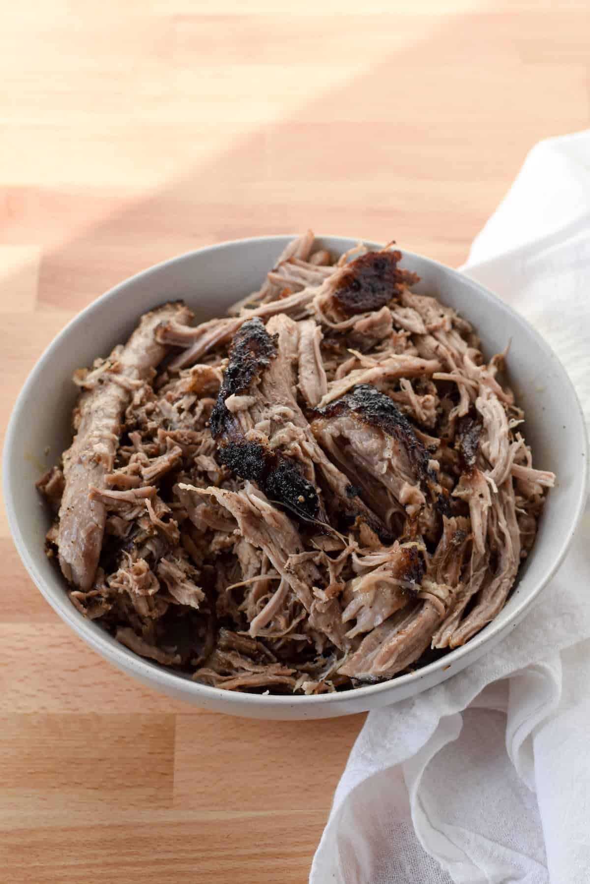 Fork-tender air fryer pulled pork shredded in a bowl.