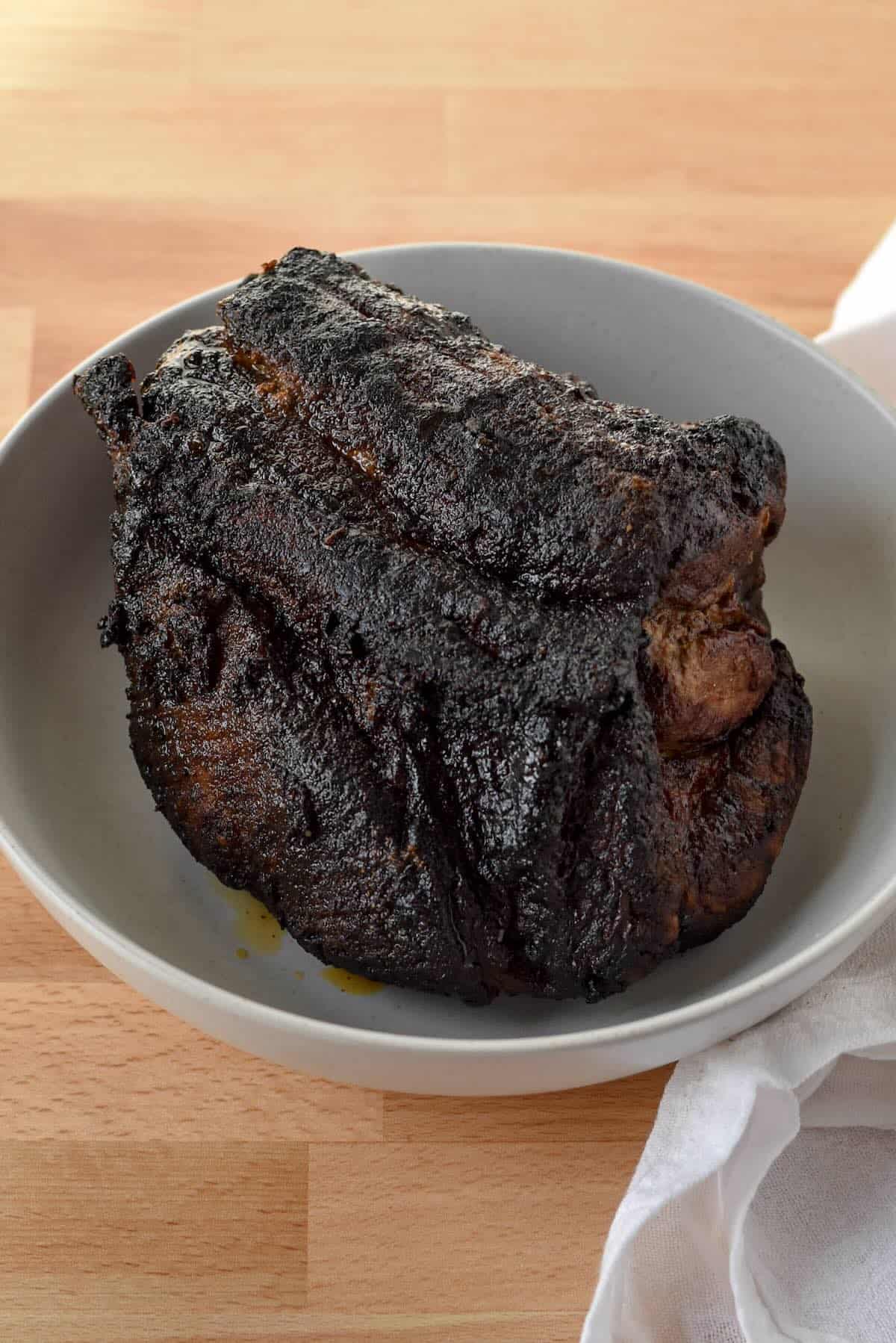 Cooked pork shoulder after air frying, browned on the outside and ready to rest before shredding.