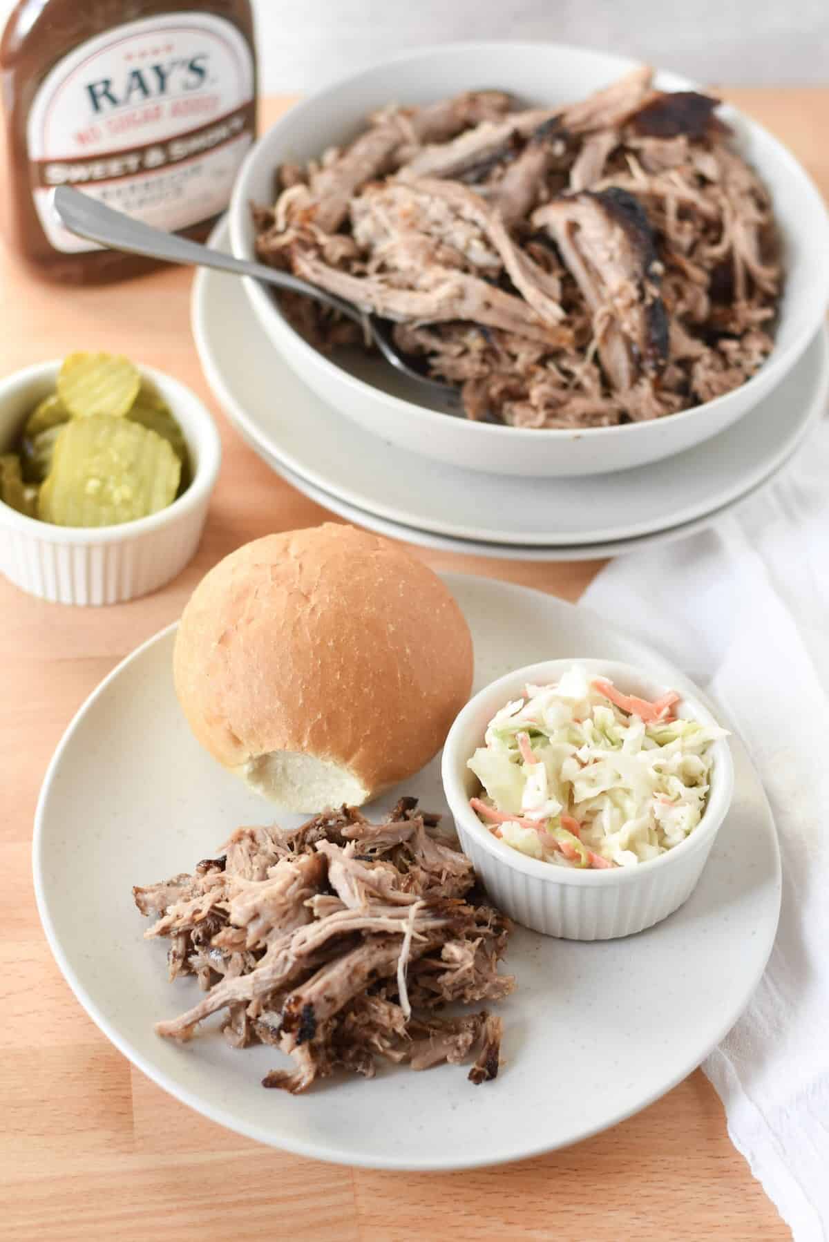 Air fryer pulled pork with on a soft bun with barbecue sauce and coleslaw.