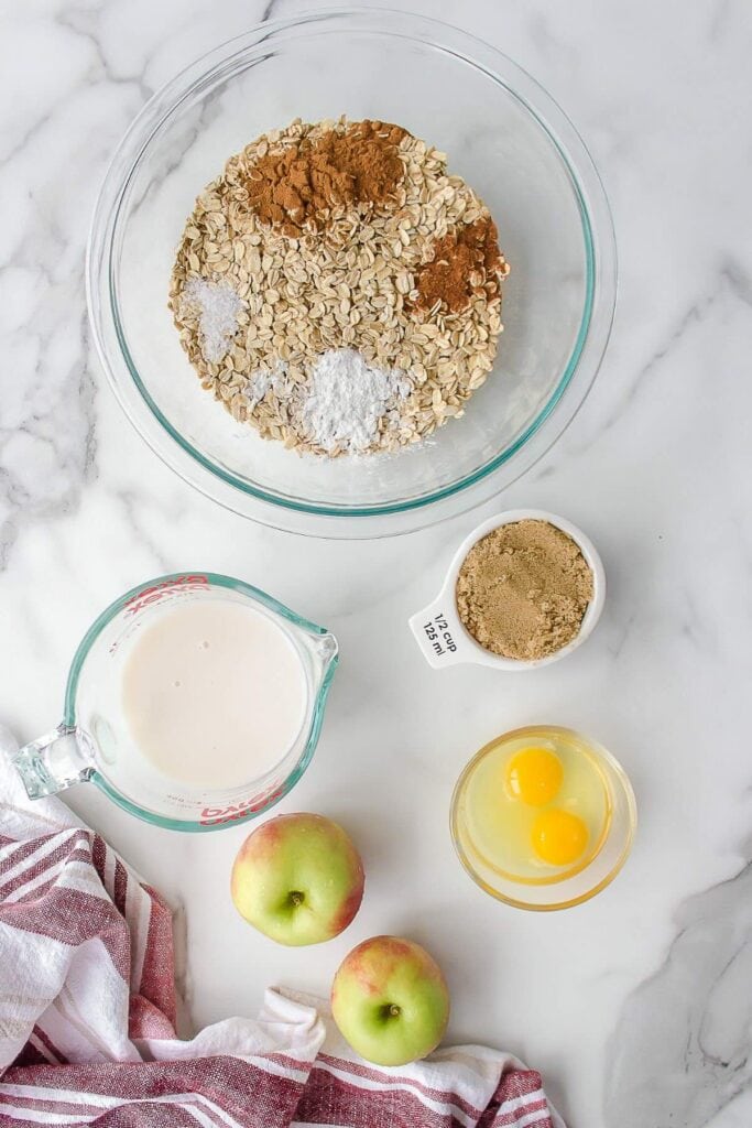 Ingredients needed to make apple baked oatmeal including oats and fresh apples.
